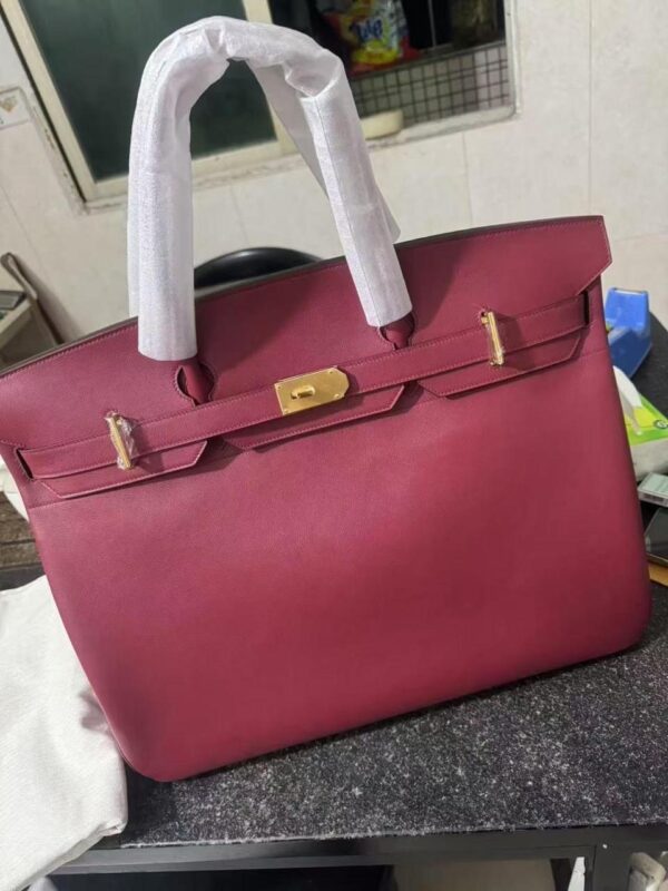 Hermès Birkin 50. Authentic quality luxury bag crafted in genuine leather comes with authenticity card, dust bag and gift bag. Grandeur in Motion. For those who believe luxury should travel as boldly as they do, the Hermès Birkin 50 is the ultimate expression of iconic design and spacious sophistication. Crafted in the finest Hermès leather, this oversized masterpiece retains all the classic Birkin elements—flawless craftsmanship, signature lock and key, and impeccable structure—on a grander scale. More than a statement, the Birkin 50 is made for movement. Whether you're jet-setting for business or escaping for leisure, it holds your world with effortless grace. From polished airport arrivals to stylish weekend retreats, it’s not just luggage—it’s legacy. Roomy. Regal. Remarkably Hermès.